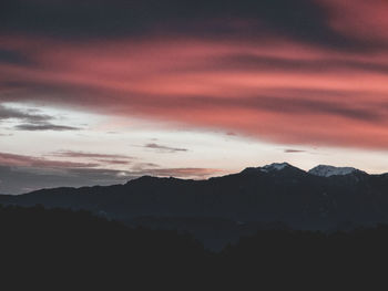 Scenic view of silhouette mountains against dramatic sky