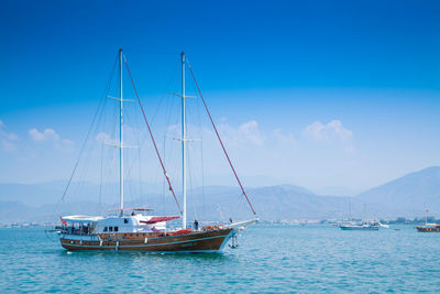 Sailboat sailing on sea against blue sky