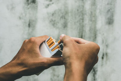 Close up man hand holding peel it off cigarette pack prepare smoking a cigarette. packing line up.