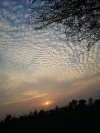 Scenic view of silhouette field against sky at sunset