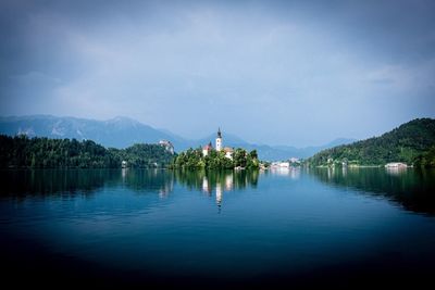 Scenic view of lake by buildings against sky