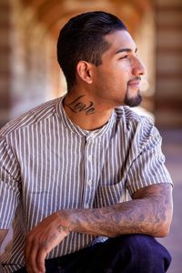 Man with love tattoo on neck in corridor