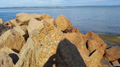 Shadow of rock on beach against sky