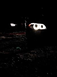 Close-up of illuminated lighting equipment on wall at night