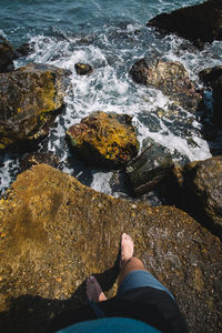 Low section of man on rock at beach