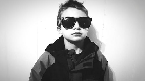 Portrait of boy wearing sunglasses against white background