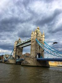 View of bridge over river against cloudy sky