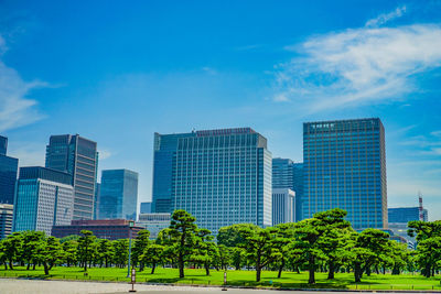 Modern buildings in city against blue sky