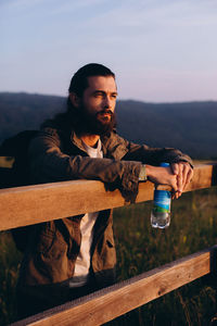 Full length of man standing by railing against sky