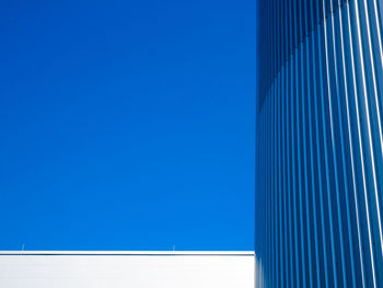 Low angle view of modern building against clear blue sky