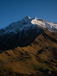 Scenic view of snowcapped mountains against clear blue sky