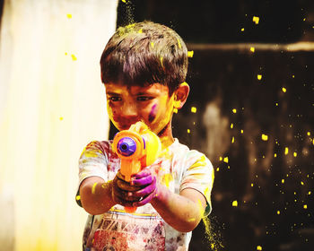 Side view of young woman blowing bubbles at night