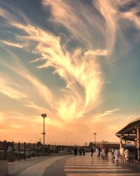 People on road against sky during sunset