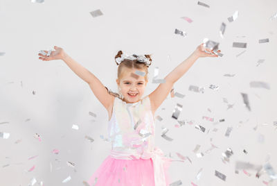 Portrait of happy girl with arms raised