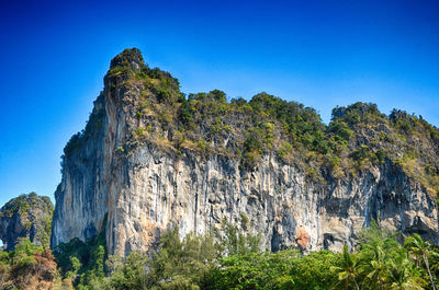 Low angle view of rock formation against clear blue sky