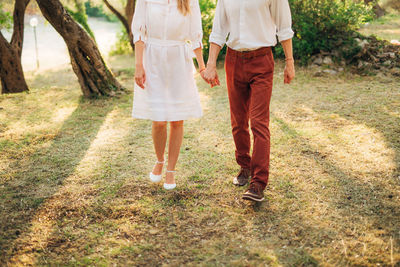 Low section of couple walking on road