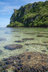 Scenic view of rocks on beach against sky