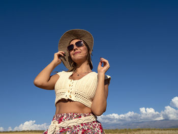 Portrait of woman standing against clear blue sky