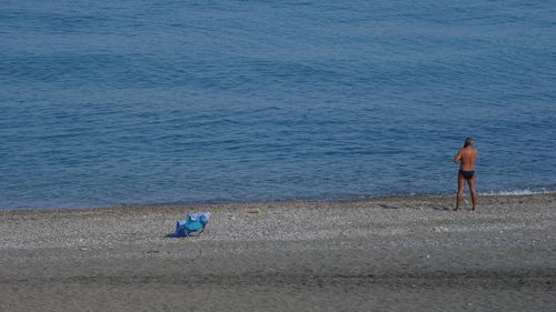 Rear view of men walking on beach