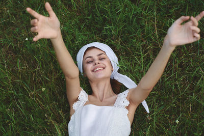 Young woman using mobile phone while standing on grassy field