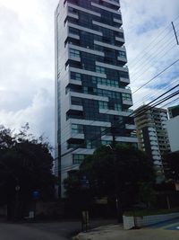 Low angle view of buildings against cloudy sky