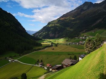 Scenic view of agricultural field by mountains against sky