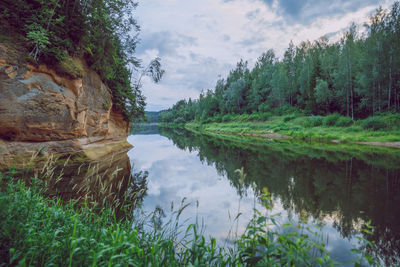 Scenic view of lake by trees against sky