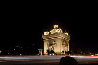 Statue in city at night