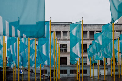 Low angle view of buildings and flagpoles against  sky