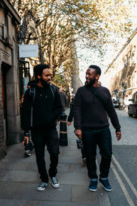 Full length portrait of young couple walking in city