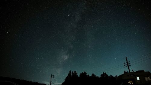 Low angle view of silhouette trees against sky at night