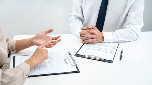 Midsection of real estate agent and client shaking hands