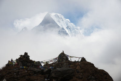 Low angle view of cross on mountain against sky