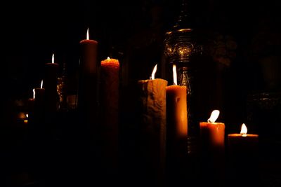 Illuminated candles against black background