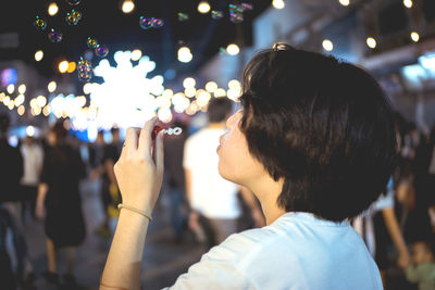 Close-up of woman blowing bubbles