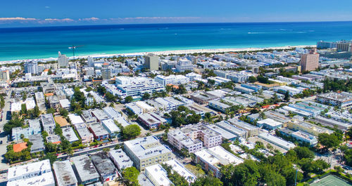 High angle view of buildings by sea against sky