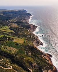 Aerial view of wild coastline with atlantic ocean waves rolling on the cliffs near praia da foz