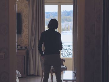 Rear view of woman standing in corridor