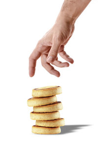Close-up of hand holding stack against white background