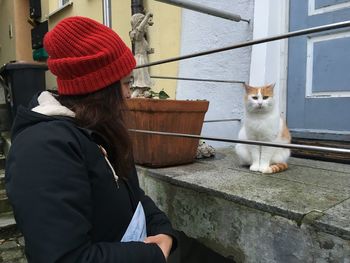 Woman looking at cat in city