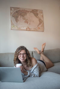 Portrait of smiling woman using mobile phone at home