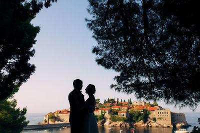 Rear view of couple standing against sky