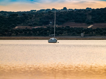 Sailboat on land against sky during sunset