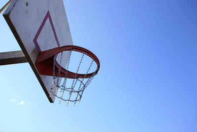 Low angle view of basketball hoop against clear blue sky