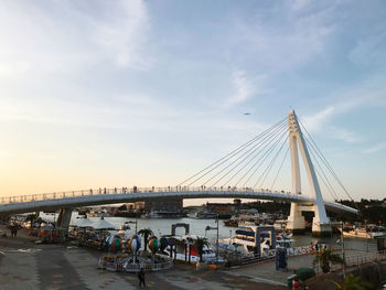 Bridge over river in city against sky