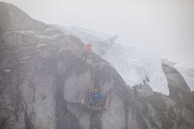 People on rock in snow