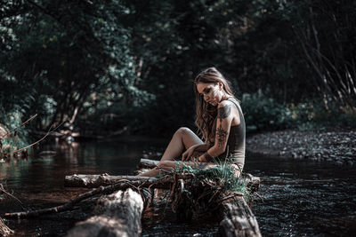 Man sitting by lake in forest