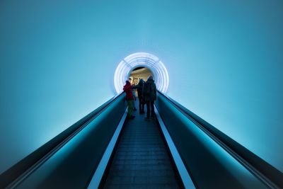 People standing on moving walkway in building