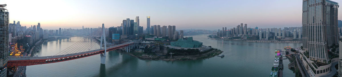 Aerial view of chongqing at sunset with qiansimen bridge and grand theatre on foreground