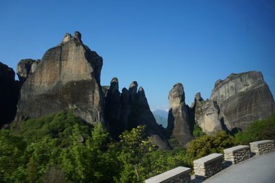 Low angle view of rock formation against clear blue sky